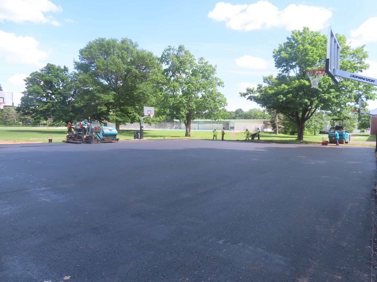 Parking Lot & Athletic Surface Base Paving project in East Hartford, CT — paver laying asphalt on court