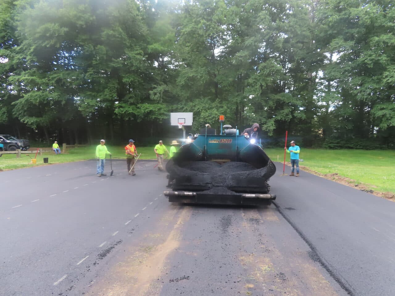 Parking Lot & Athletic Surface Base Paving project in East Hartford, CT — paver laying asphalt with crew