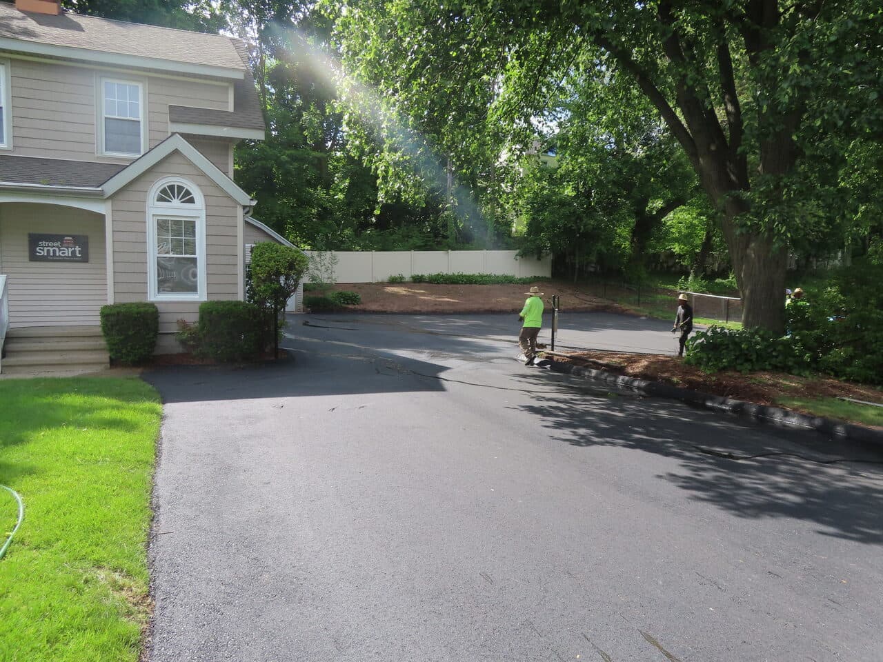 Commercial Driving School Parking Lot Paving project in Hamden, CT — finished driveway with workers nearby