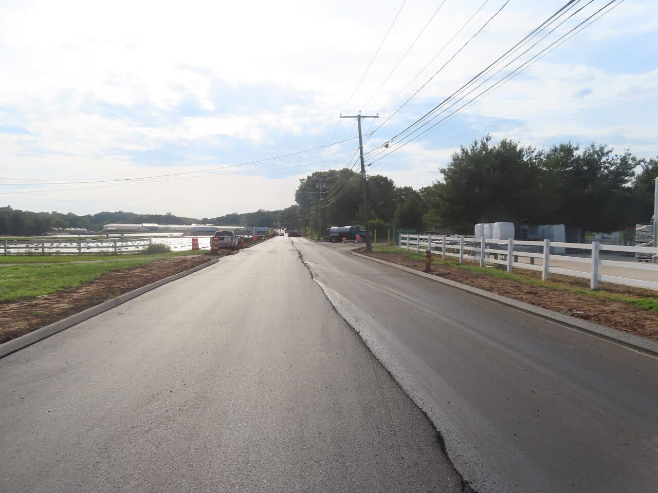 Roadway Paving project in Cheshire, CT — finished road by white fence