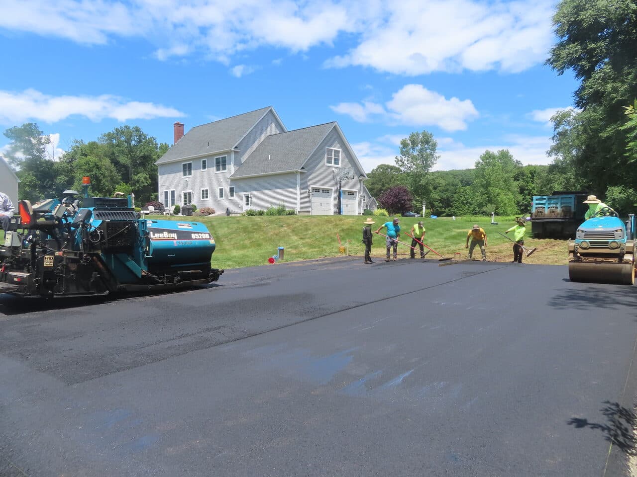 Asphalt Pad Paving project in North Haven, CT — crew raking hot asphalt with paver