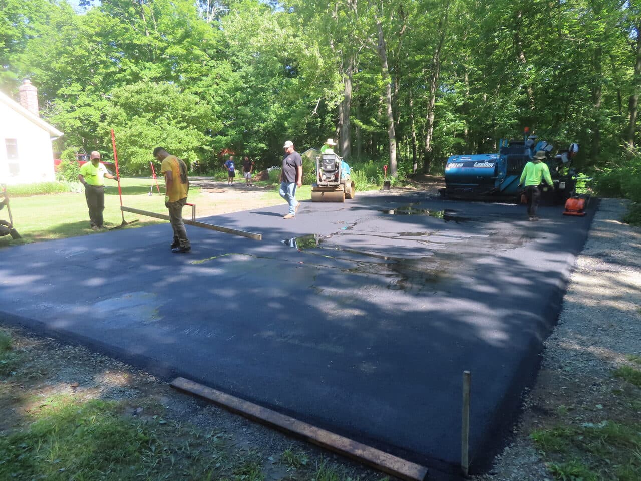Multi-Stop Residential Driveway Paving project in Durham & Wallingford, CT — fresh asphalt parking pad being compacted