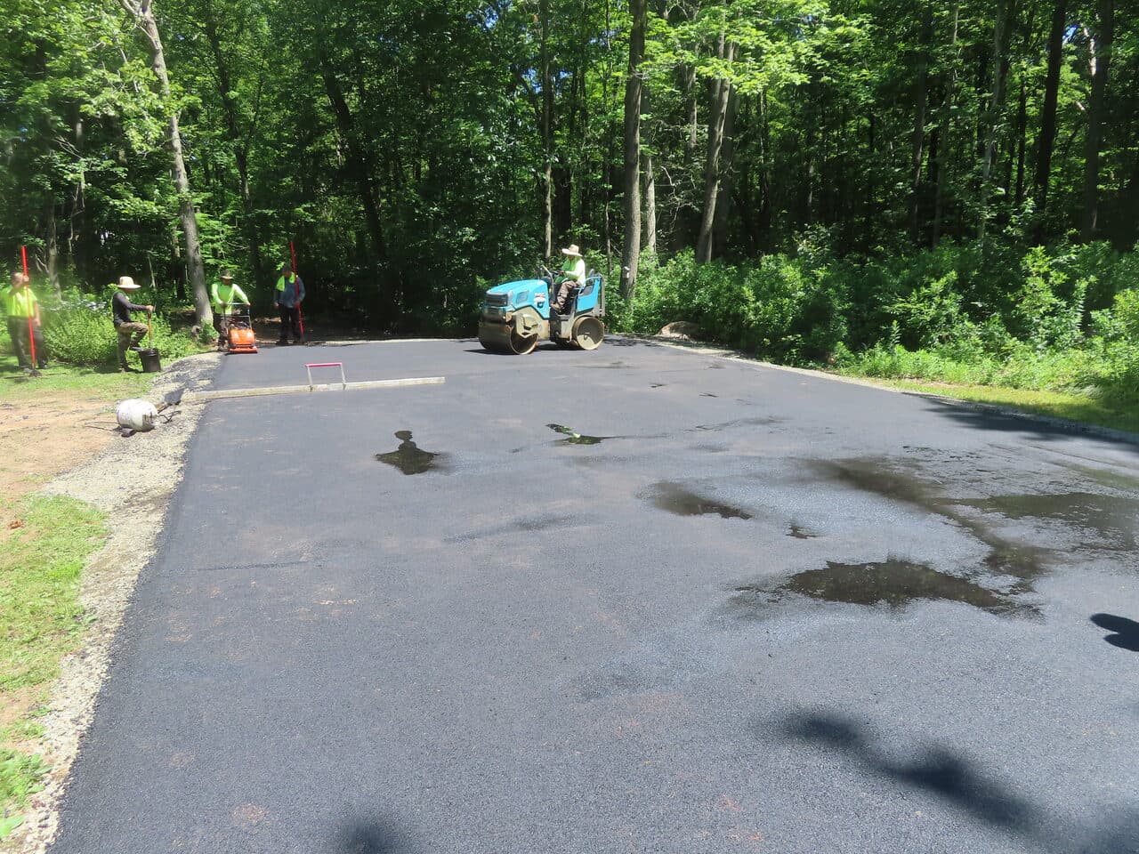 Multi-Stop Residential Driveway Paving project in Durham & Wallingford, CT — roller compacting finished driveway