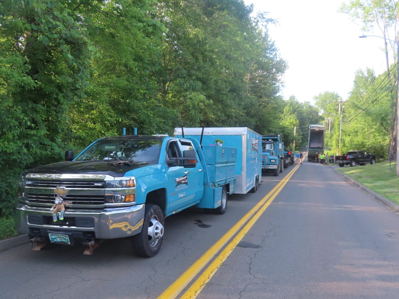 Multi-Stop Residential Driveway Paving project in Durham & Wallingford, CT — blue MB trucks staged on road