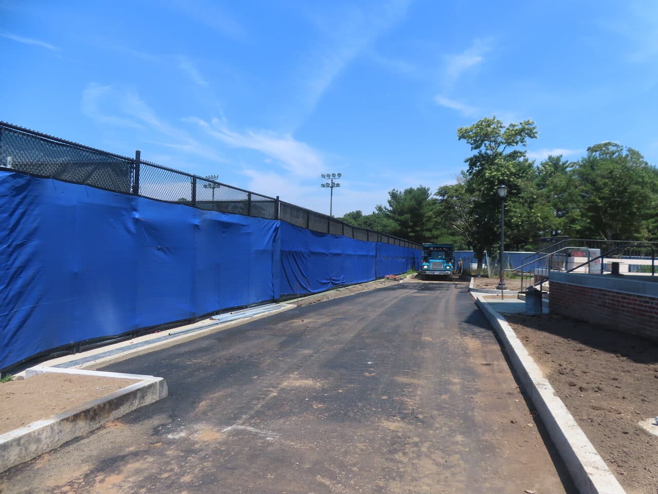 Before — Institutional Asphalt Paving in New Haven, CT (graded base before paving by fence)