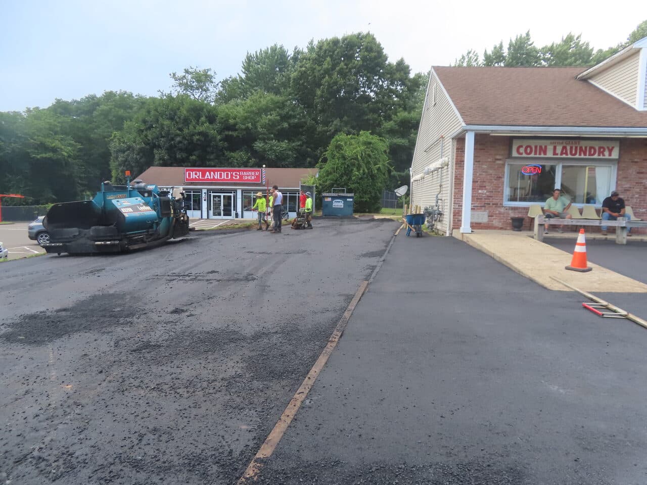 Commercial Plaza Paving project in New Haven, CT — paver and crew along laundry driveway