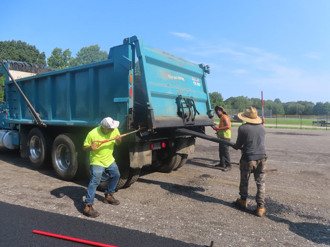 Commercial Parking Lot Paving project in Barrington, RI — crew releasing asphalt apron chains