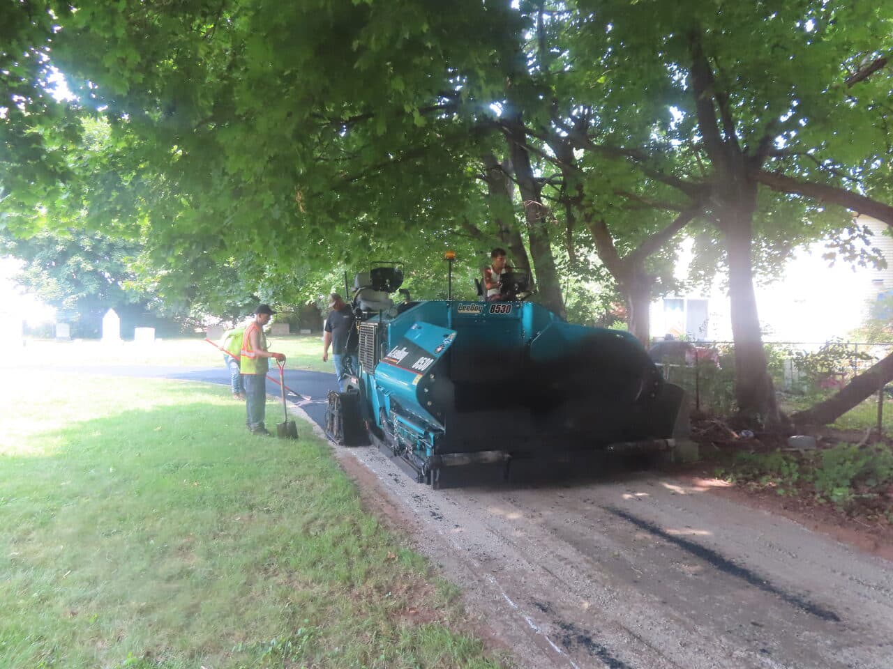 Cemetery Roadway & Walkway Paving project in East Haven, CT — paver and crew under trees