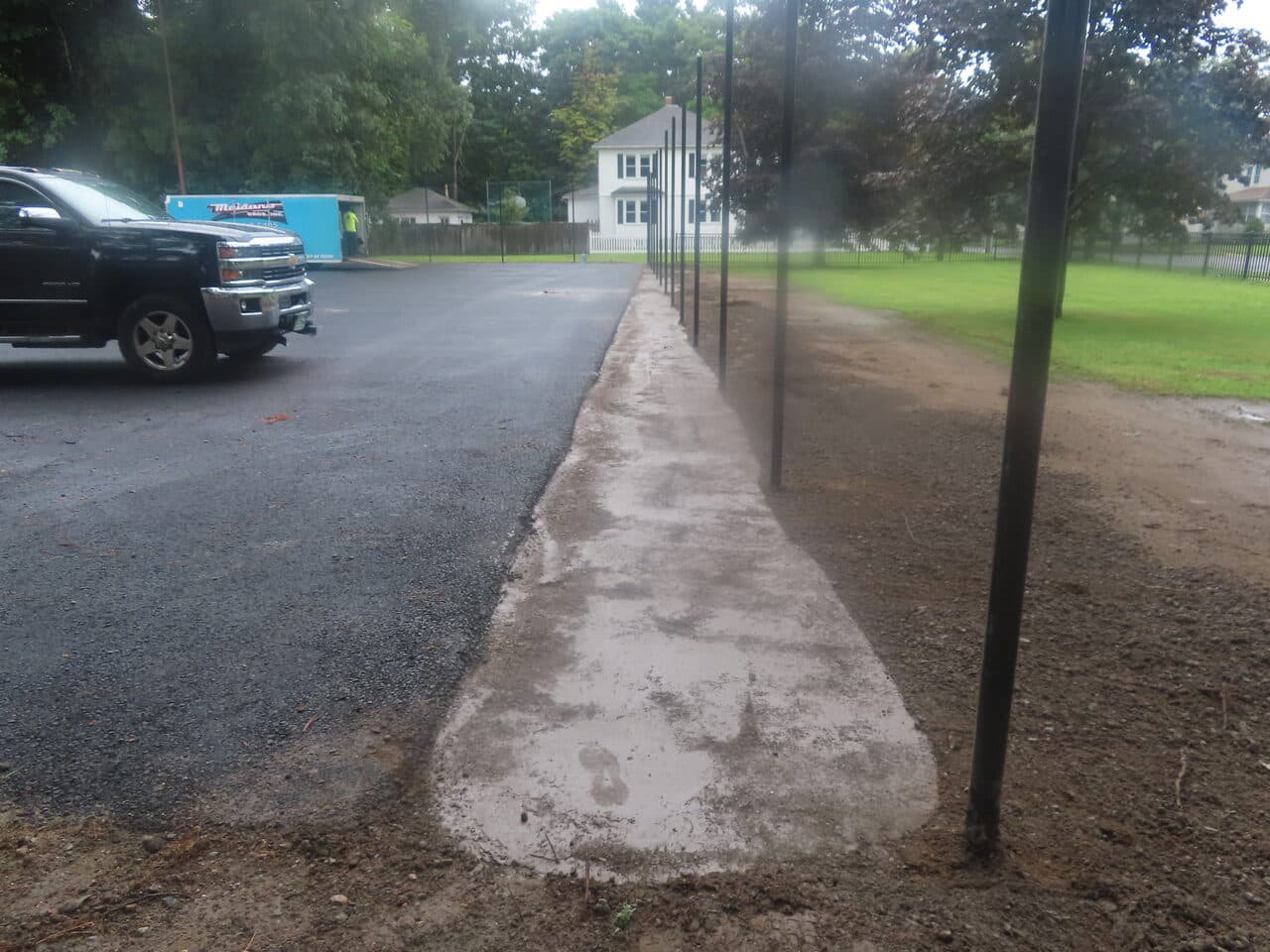 Asphalt Walkway Paving project in Springfield, MA — concrete walkway along fence line