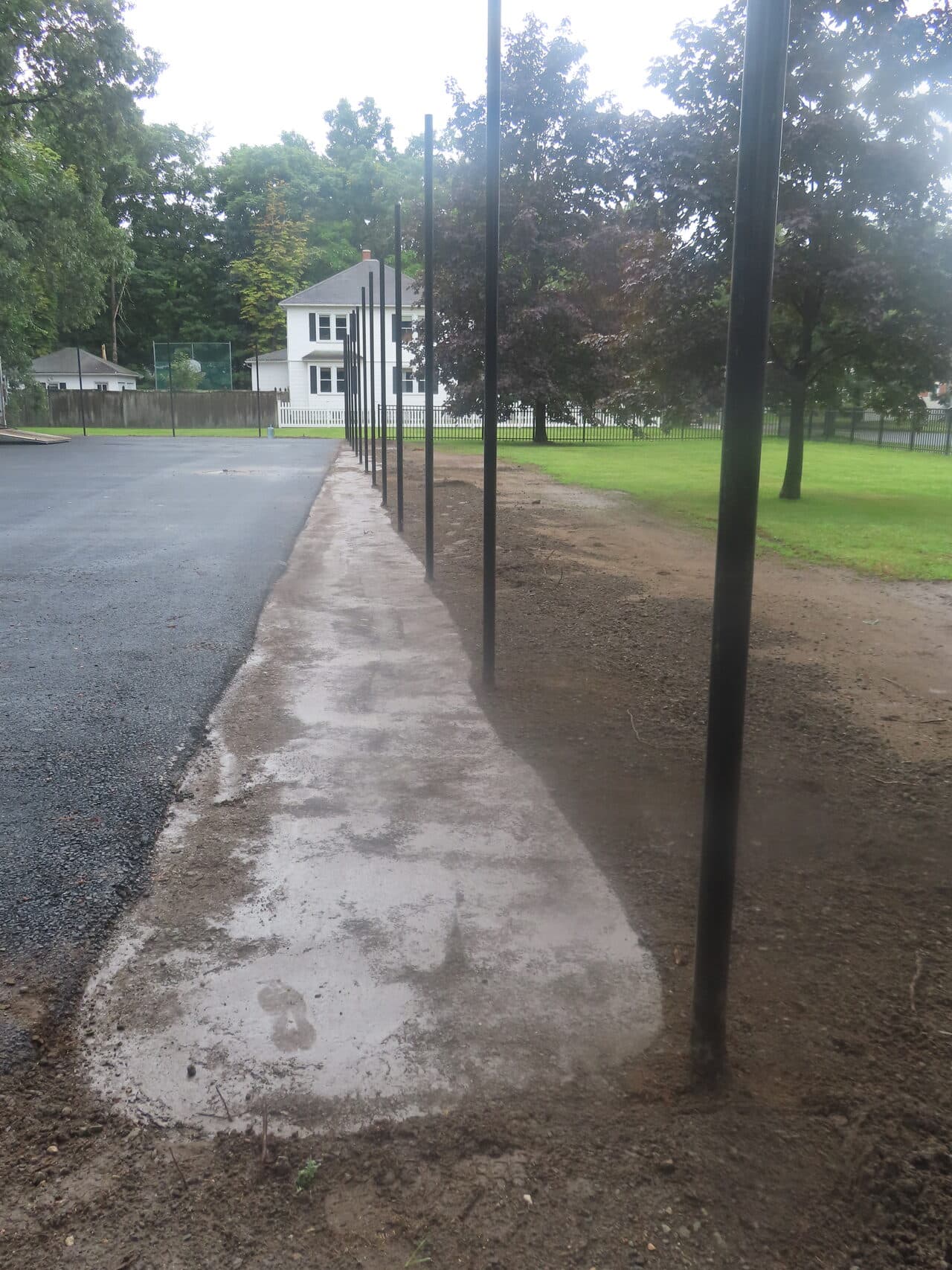 Asphalt Walkway Paving project in Springfield, MA — finished concrete walkway by fence