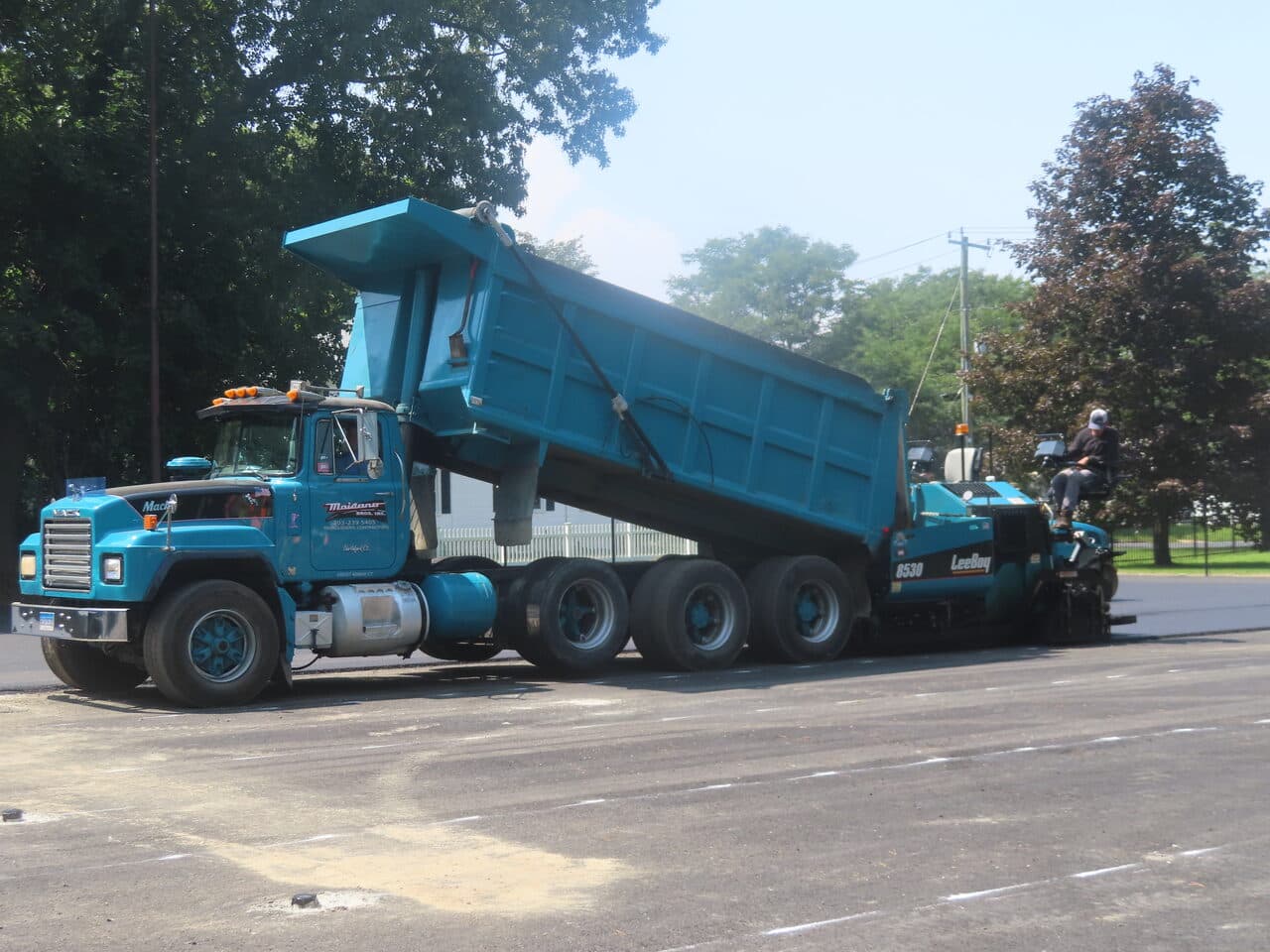Commercial Parking Lot Paving project in Springfield, MA — branded dump truck and paver
