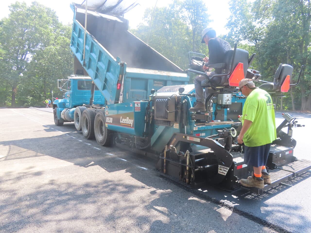 Commercial Parking Lot Paving project in Springfield, MA — paver fed by branded dump truck