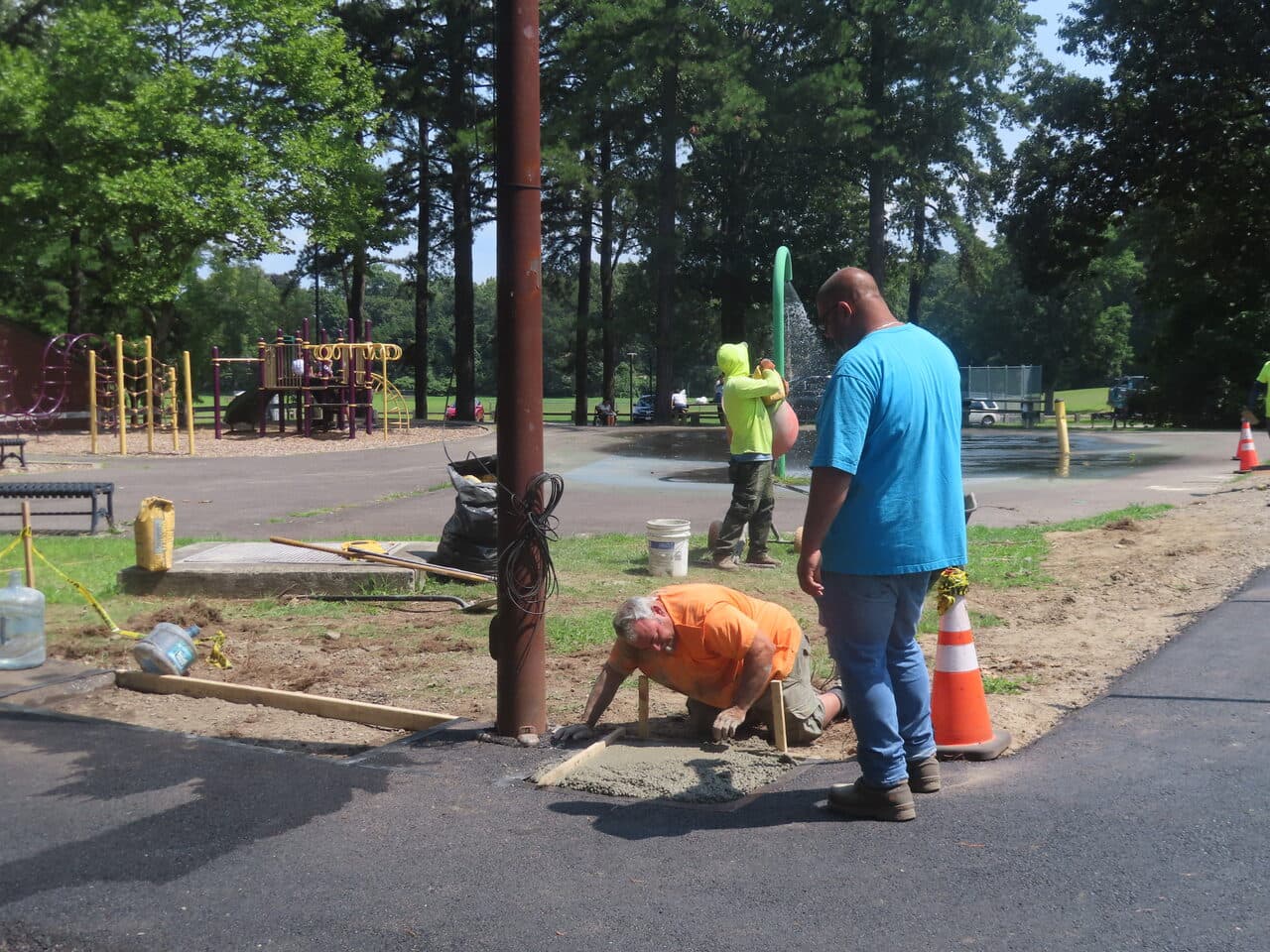 Commercial Parking Lot Paving project in Springfield, MA — workers setting light pole base