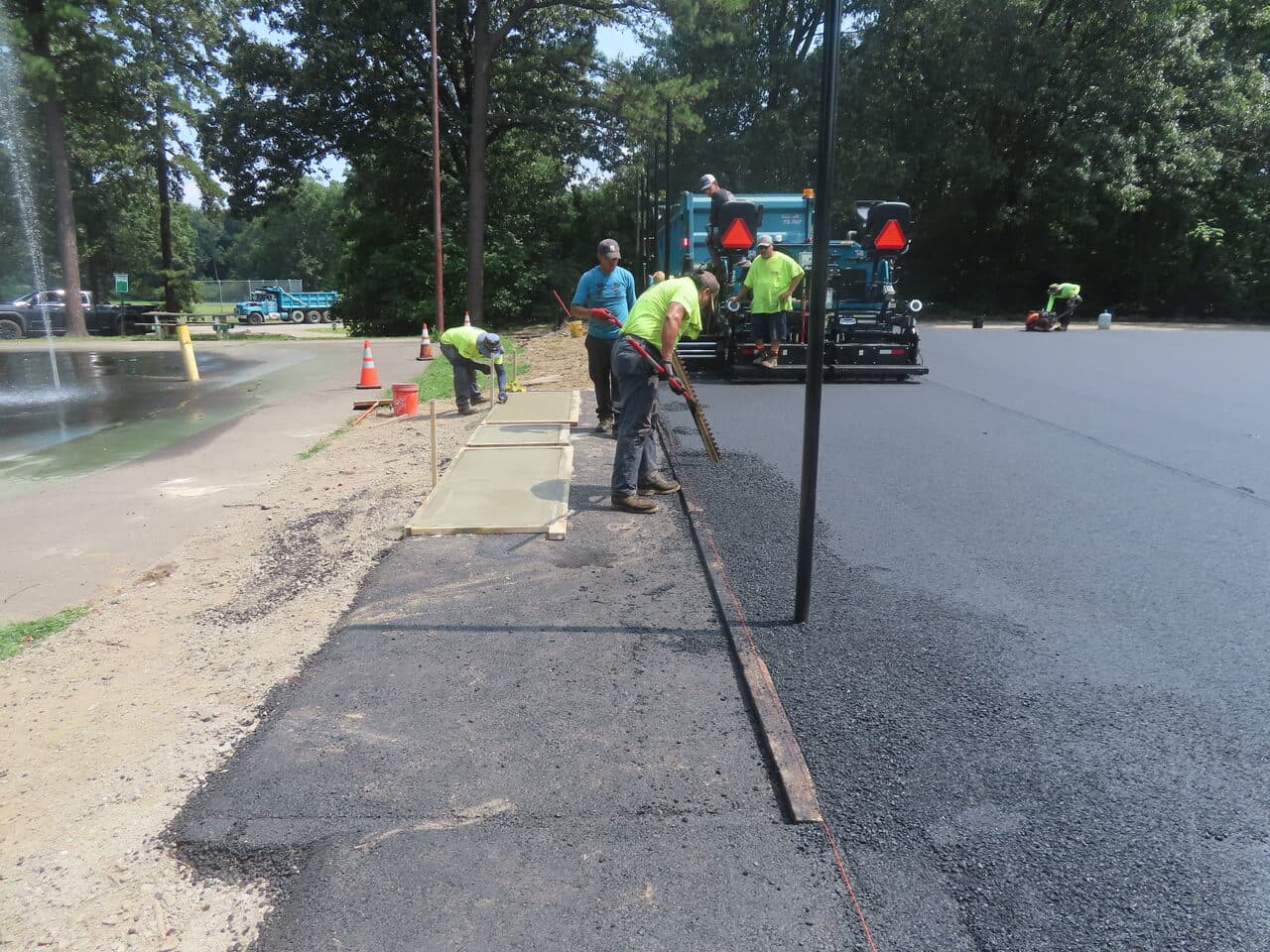 Commercial Parking Lot Paving project in Springfield, MA — new concrete walkway beside fresh asphalt