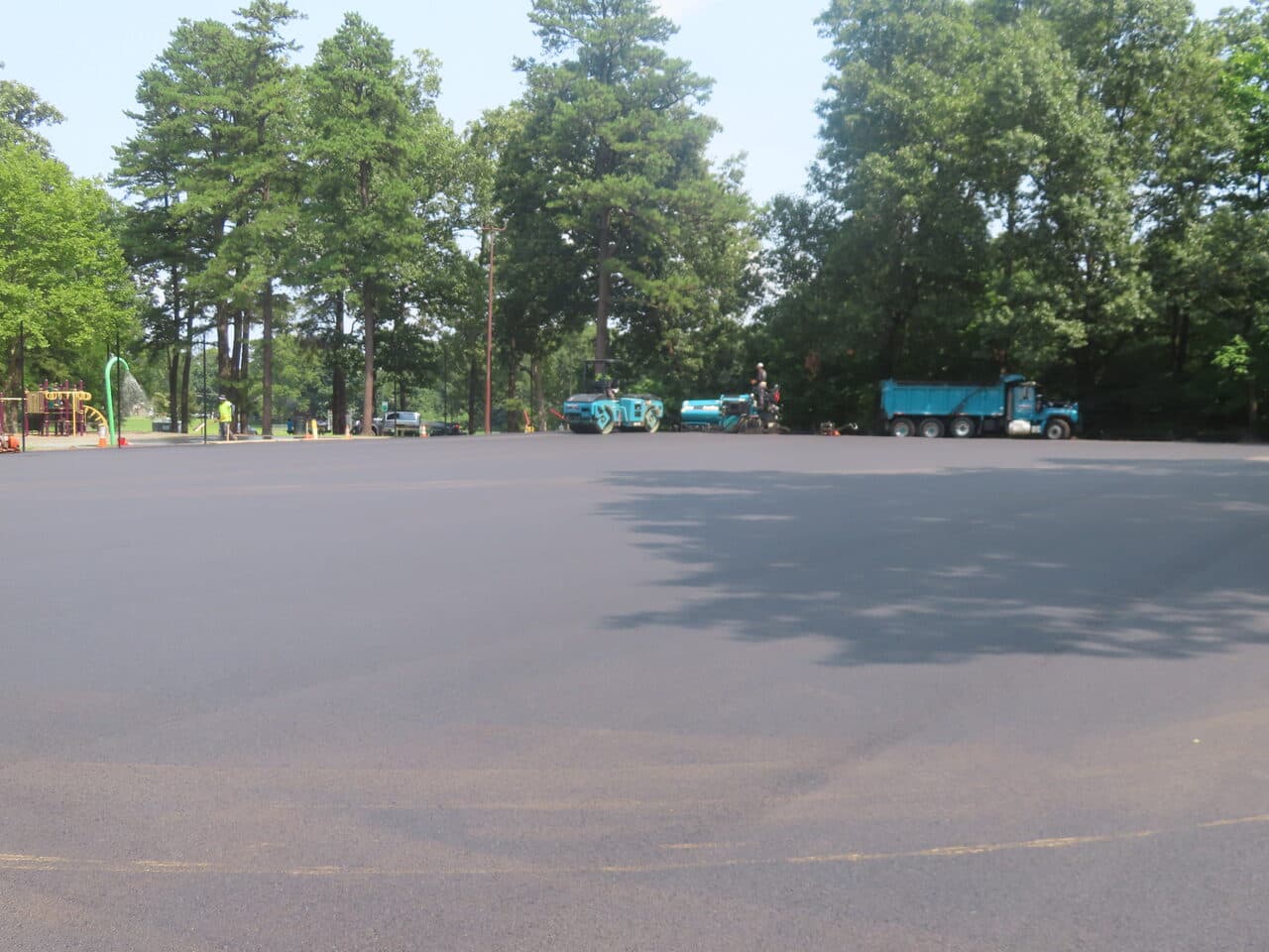 Commercial Parking Lot Paving project in Springfield, MA — wide finished lot with parked equipment