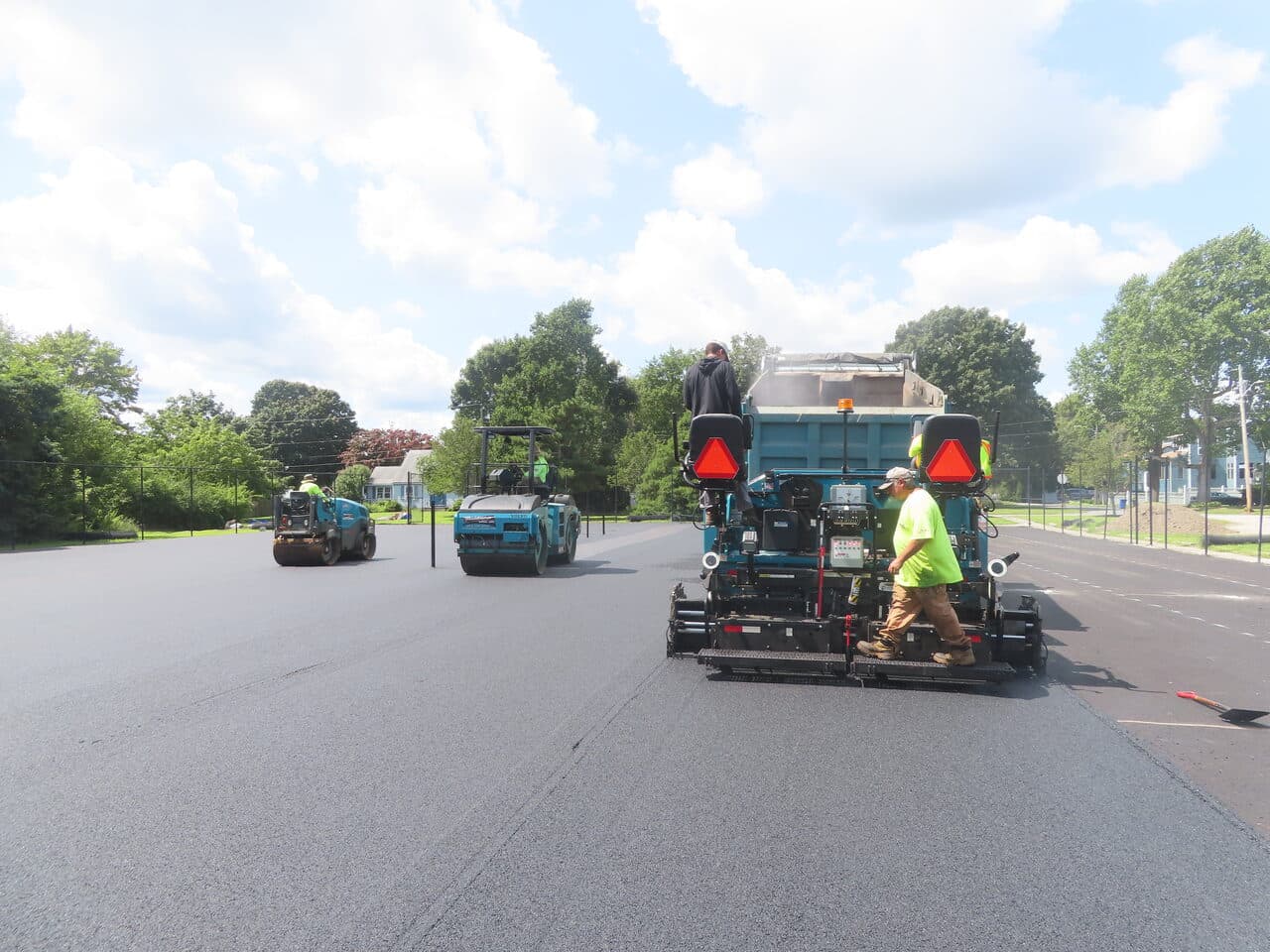 Commercial Parking Lot Paving project in Barrington, RI — paving train paver and rollers