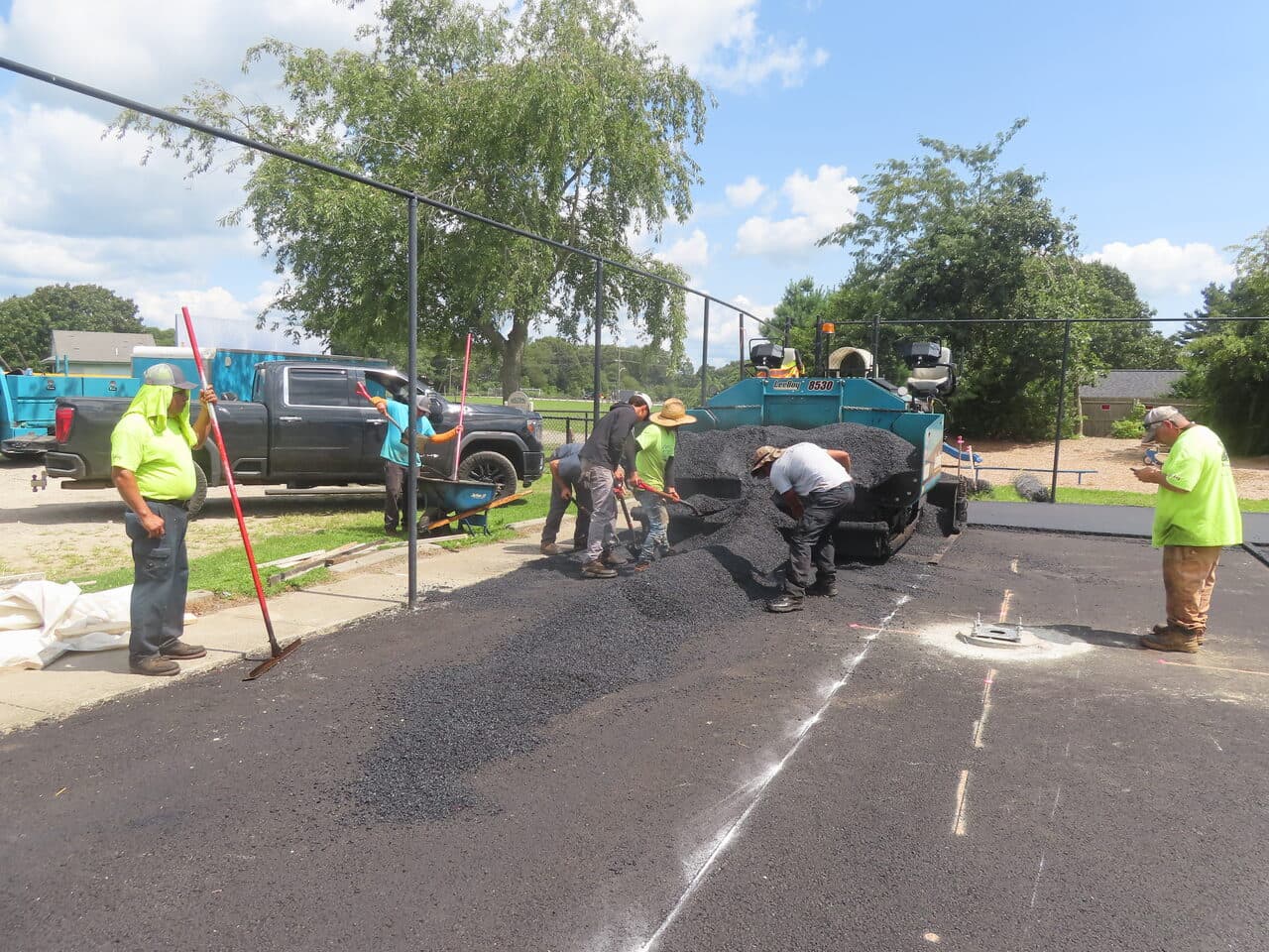 Commercial Parking Lot Paving project in Barrington, RI — crew raking around drain
