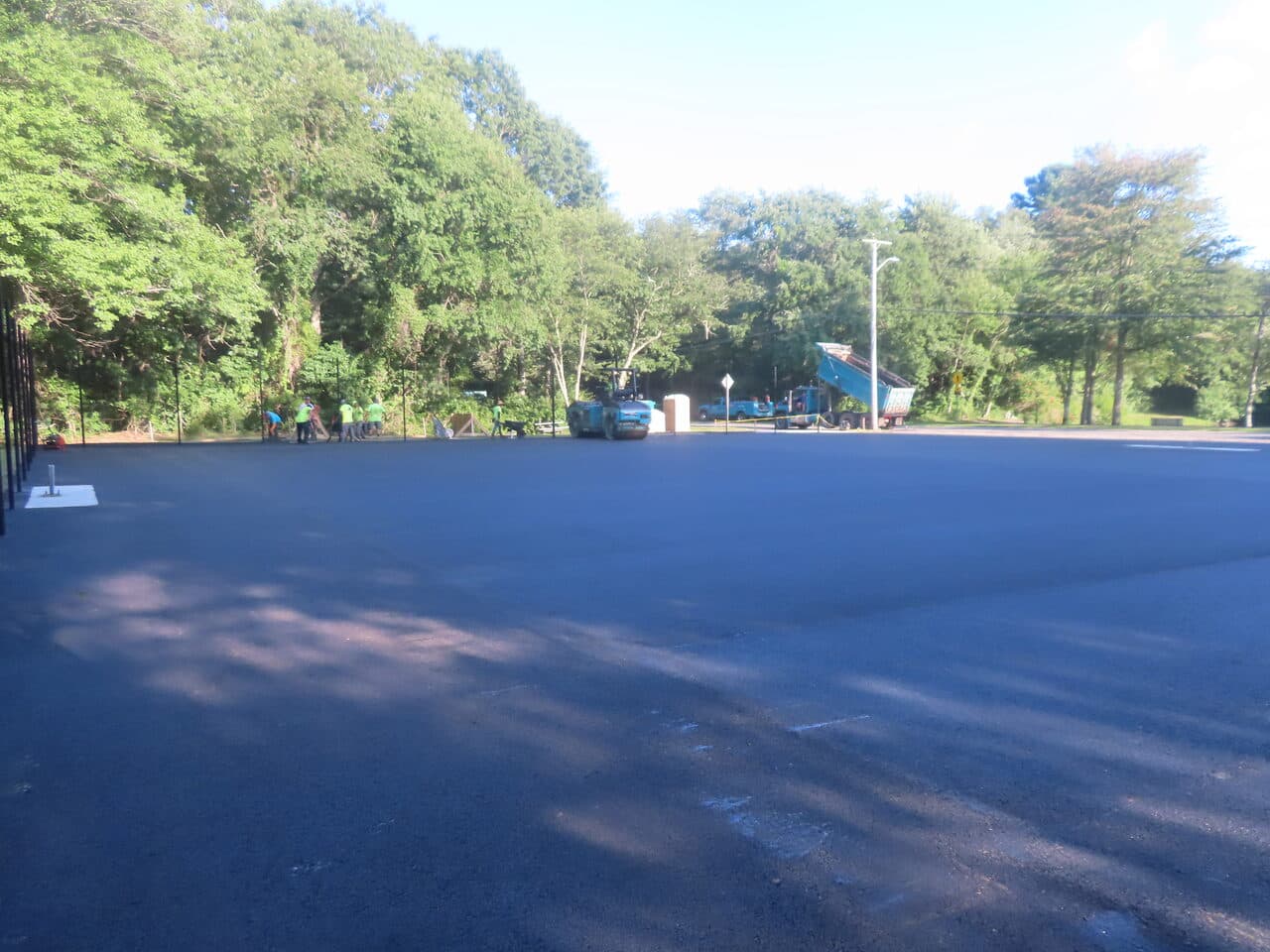Commercial Parking Lot Paving project in Barrington, RI — finished lot fence and trees