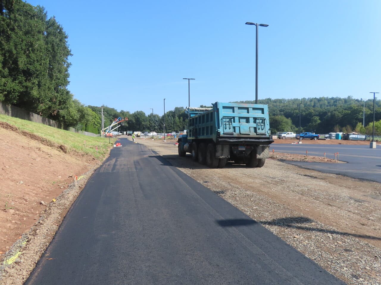 Commercial Parking Lot Paving project in North Branford, CT — fresh asphalt access road with dump truck