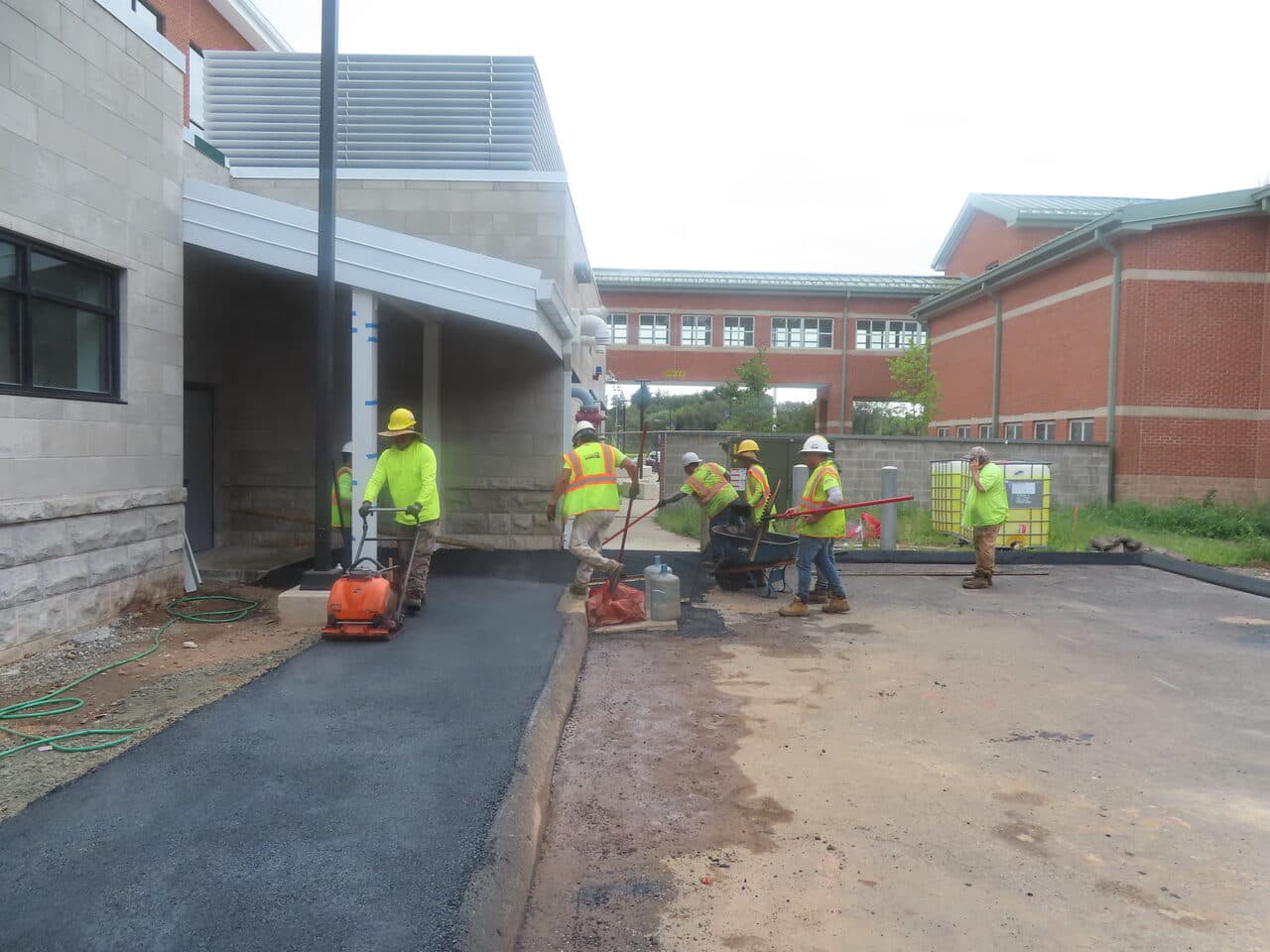 Commercial Parking Lot Paving project in North Branford, CT — crew compacting walkway asphalt
