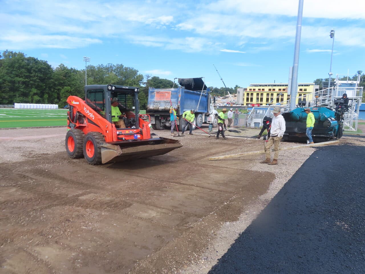 Athletic Surface Base Paving project in Burlington, VT — skid steer grading base at stadium