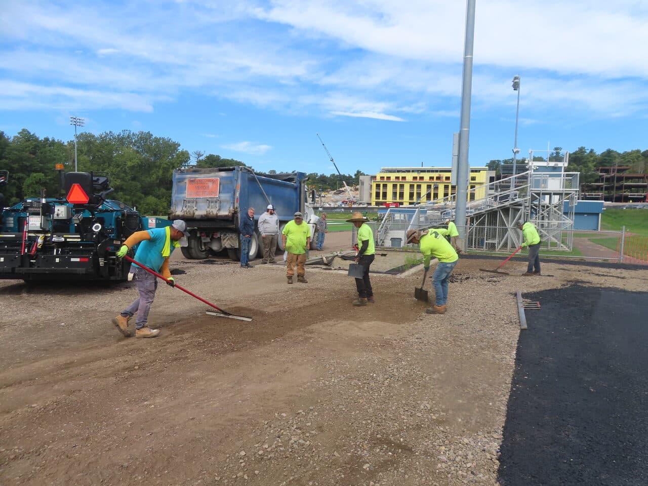 Athletic Surface Base Paving project in Burlington, VT — crew raking gravel base