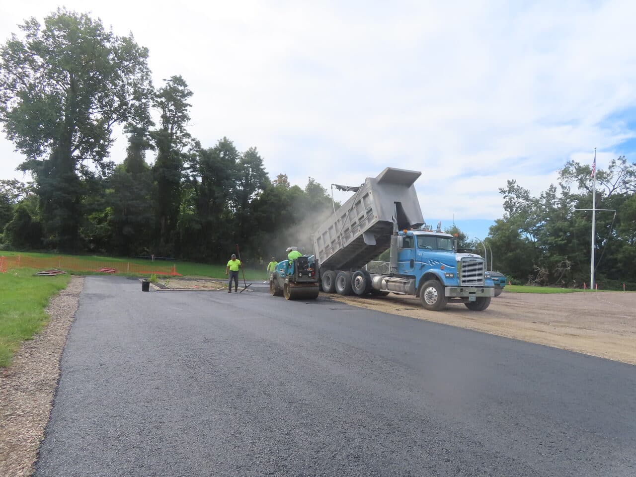 Athletic Surface Base Paving project in Burlington, VT — fresh asphalt track with dump truck