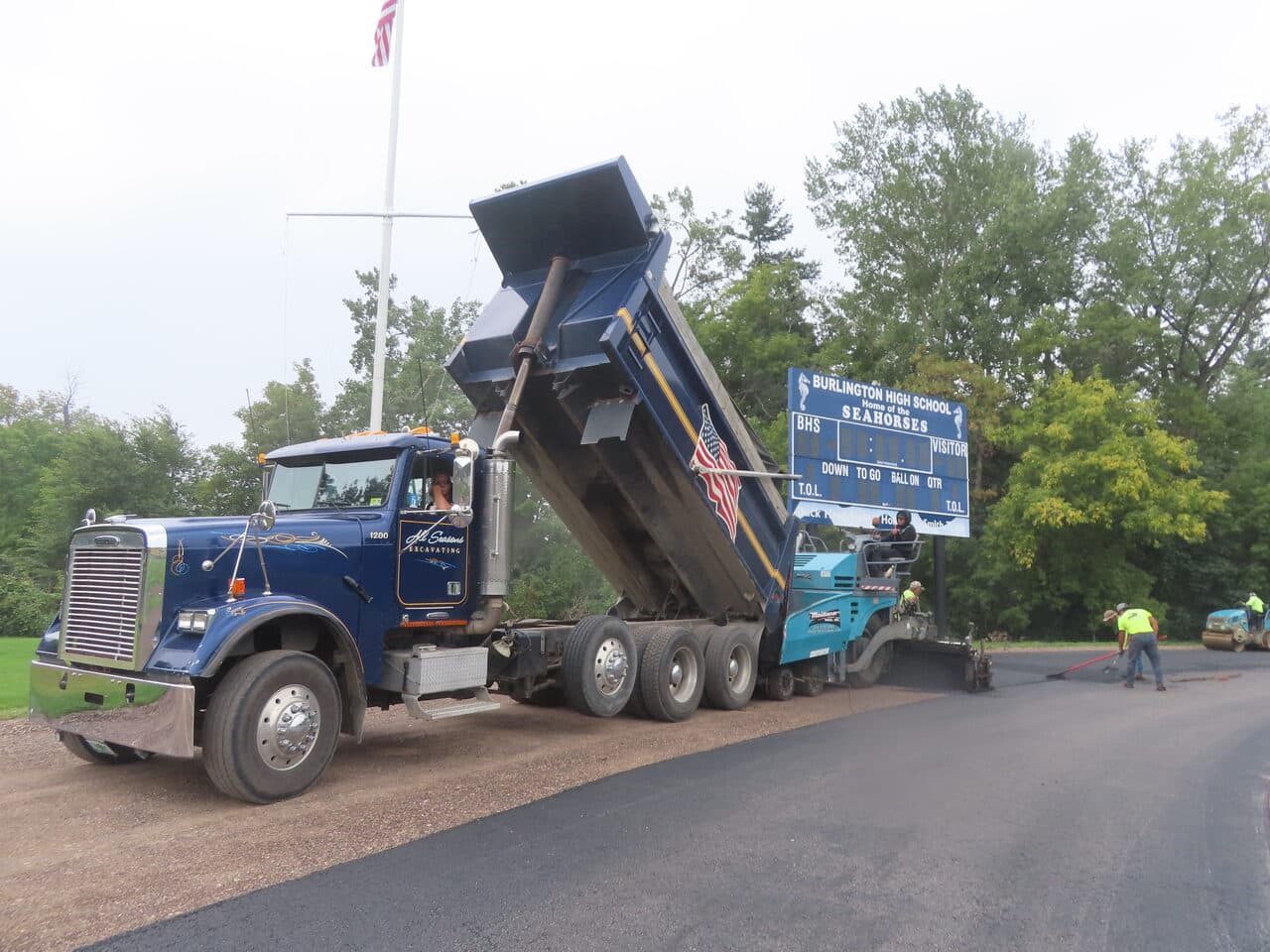 Athletic Surface Base Paving project in Burlington, VT — blue dump truck feeding paver