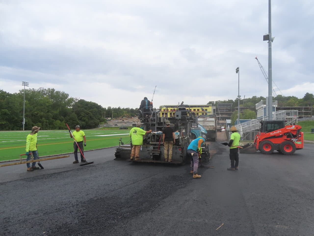 Athletic Surface Base Paving project in Burlington, VT — wide crew paving track at field