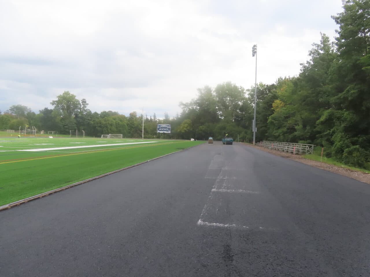 Athletic Surface Base Paving project in Burlington, VT — finished track straightaway by field