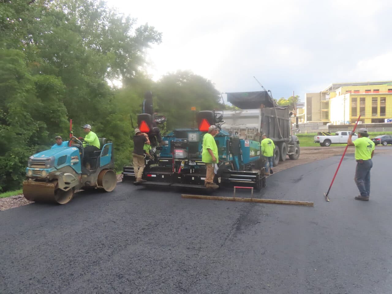 Athletic Surface Base Paving project in Burlington, VT — roller and paver train on lot