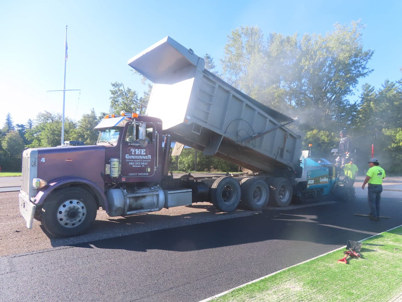 Athletic Surface Base Paving project in Burlington, VT — dump truck feeding paver
