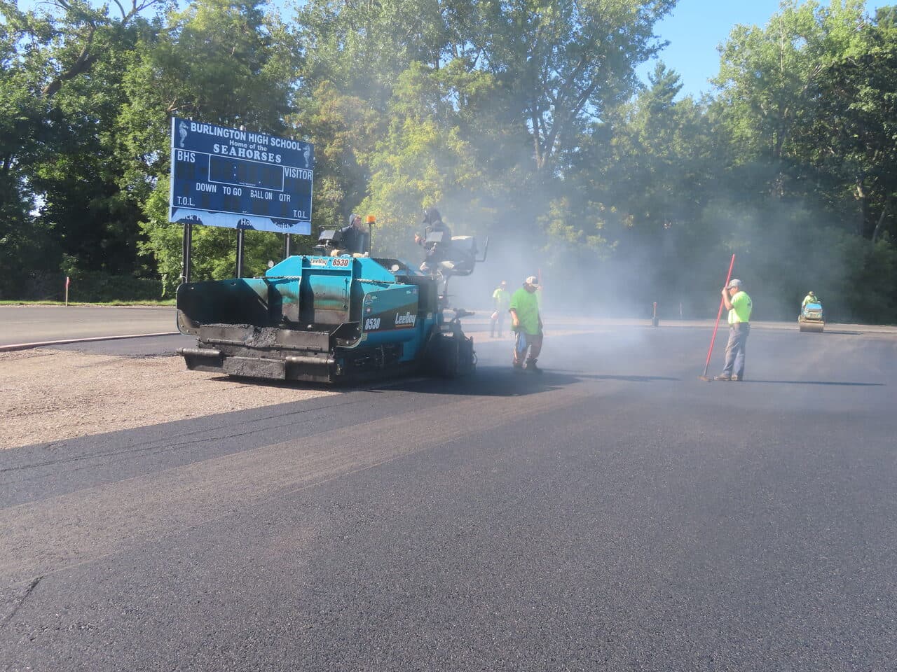 Athletic Surface Base Paving project in Burlington, VT — paver laying asphalt on track