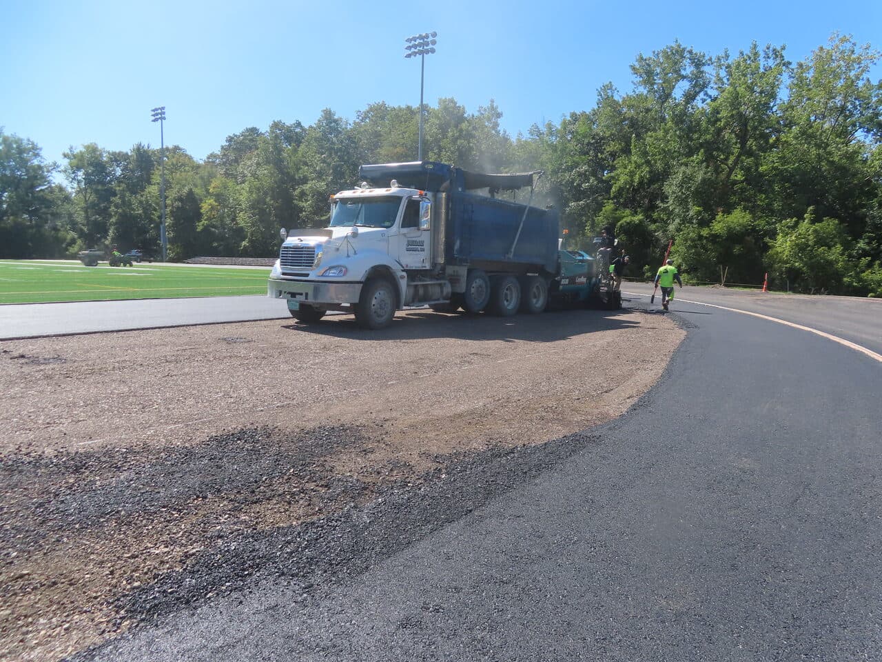 Athletic Surface Base Paving project in Burlington, VT — truck on graded base edge