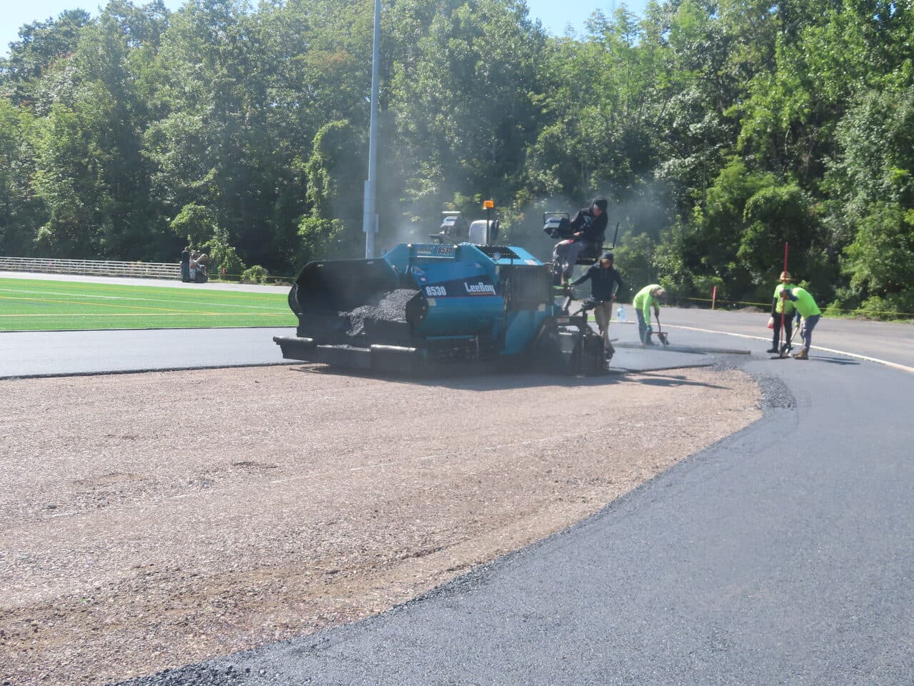 Athletic Surface Base Paving project in Burlington, VT — paver finishing curved track edge