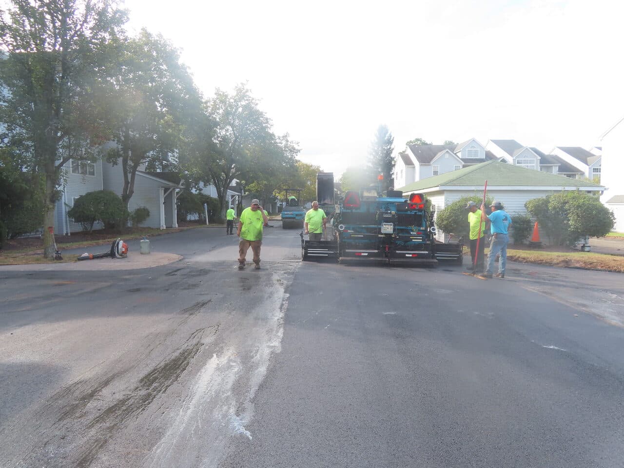 HOA Parking Lot Paving project in Hamden, CT — paver and crew on road
