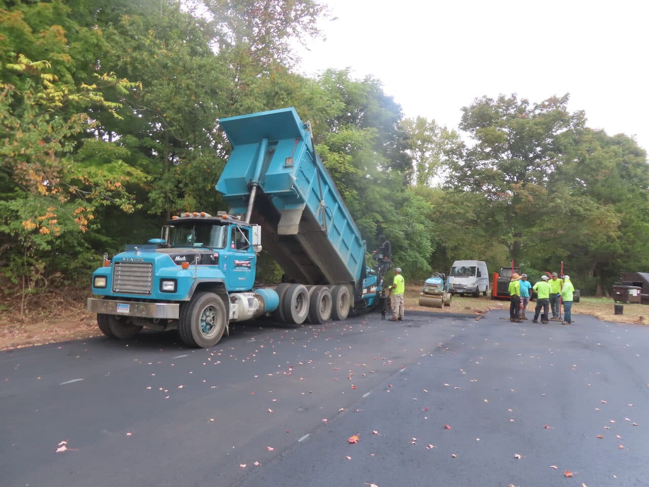 Commercial Parking Lot Paving project in Branford, CT — dump truck dumping asphalt into paver