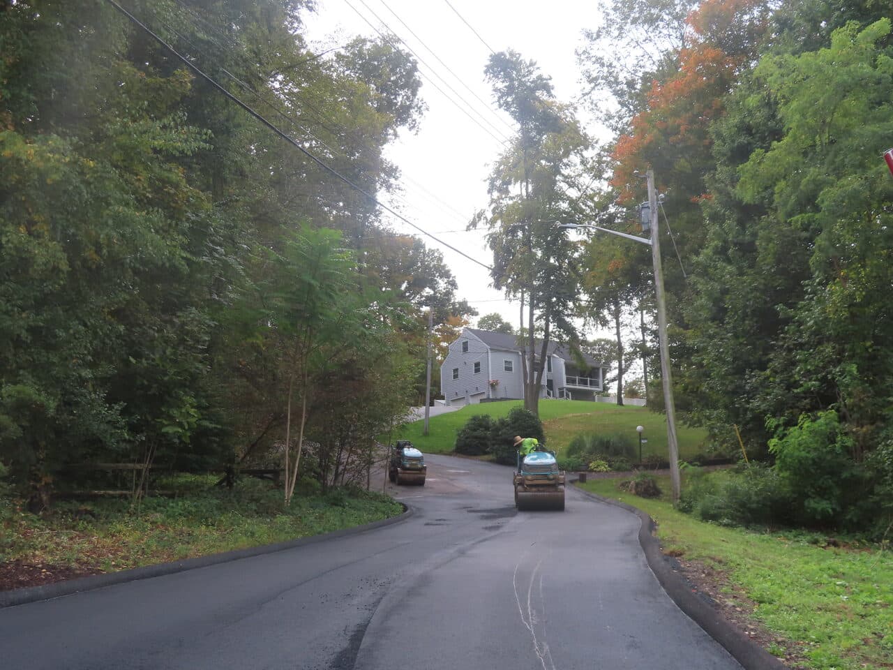 Commercial Parking Lot Paving project in North Branford, CT — finished road curve with rollers