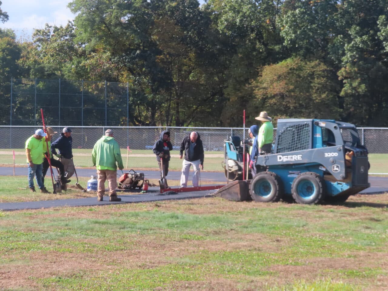 Athletic Surface Base Paving project in East Windsor, CT — crew with skid steer on track
