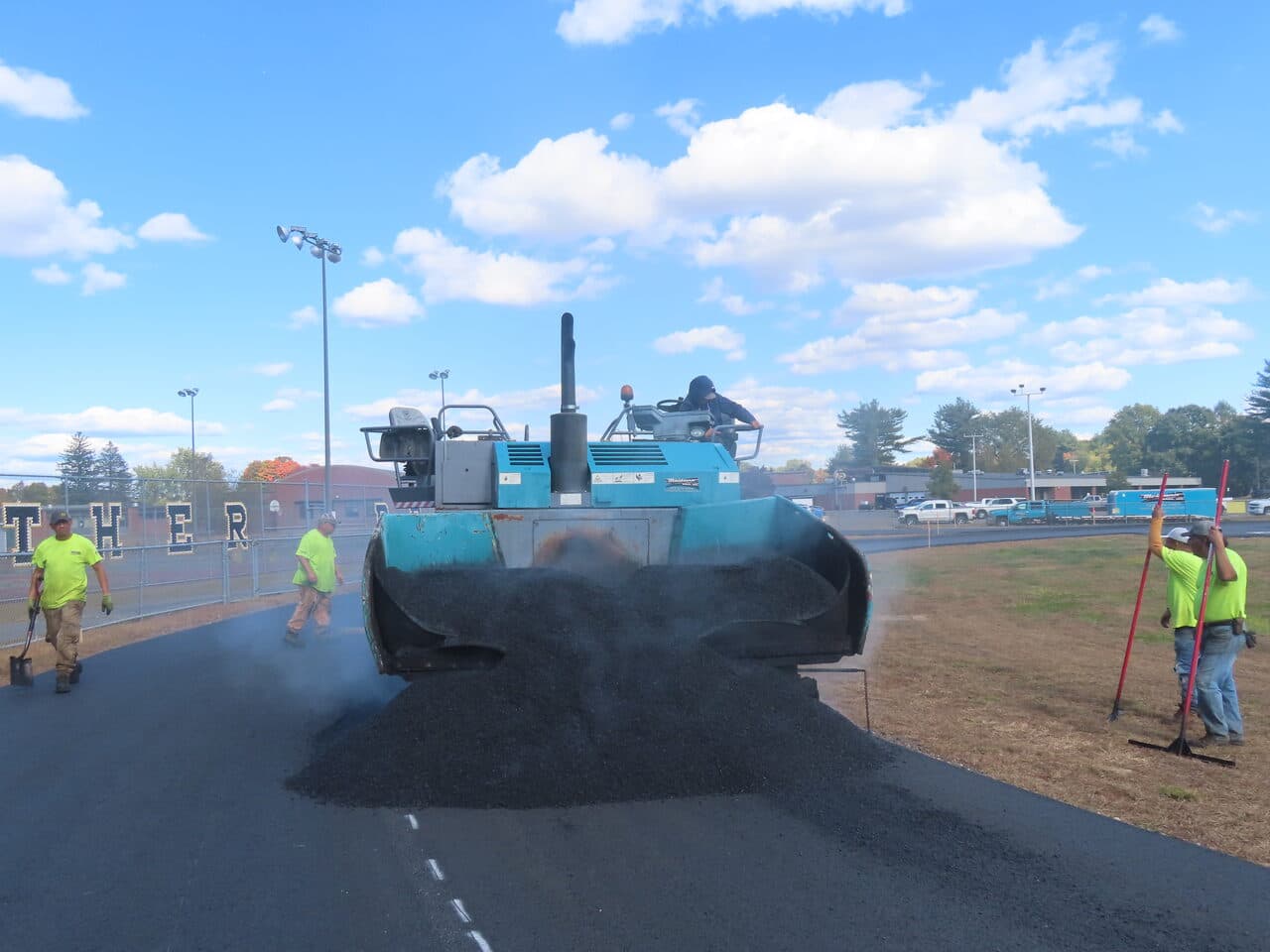 Athletic Surface Base Paving project in East Windsor, CT — paver spreading asphalt on track