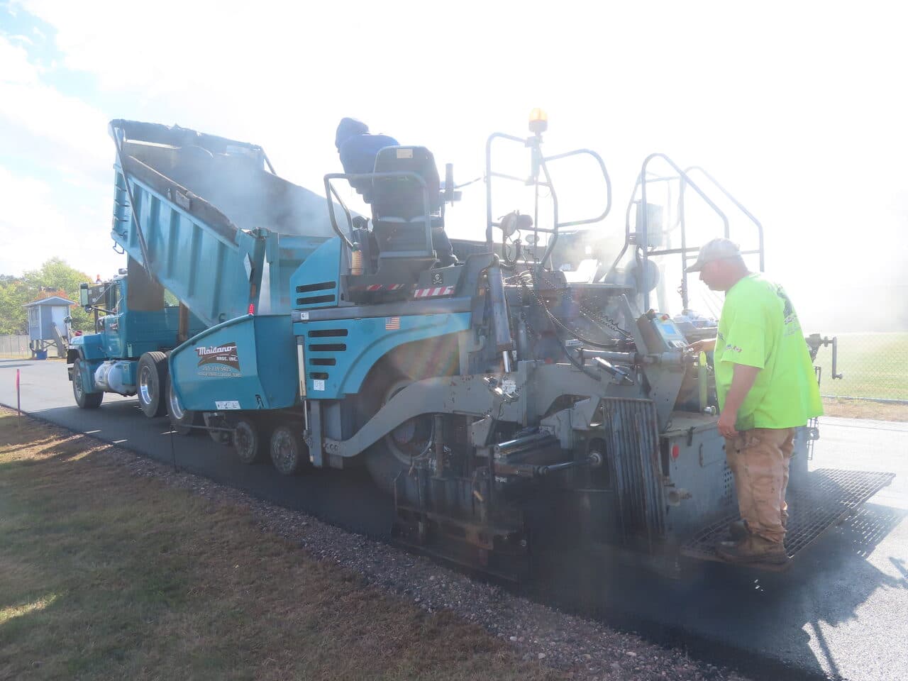Athletic Surface Base Paving project in East Windsor, CT — Maisano paver and dump truck