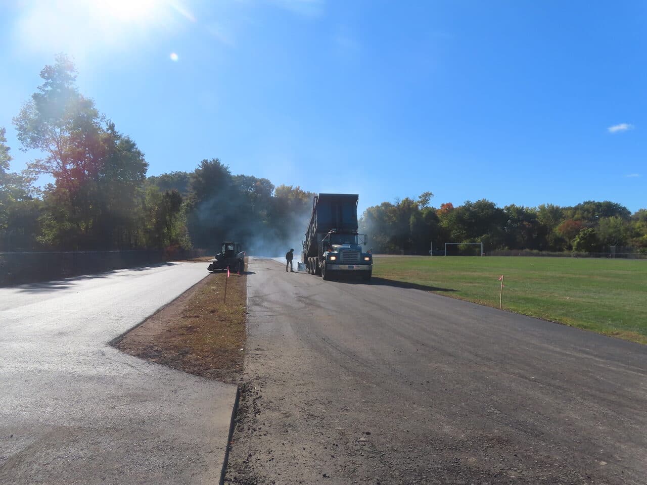 Athletic Surface Base Paving project in East Windsor, CT — dump truck and skid steer paving track