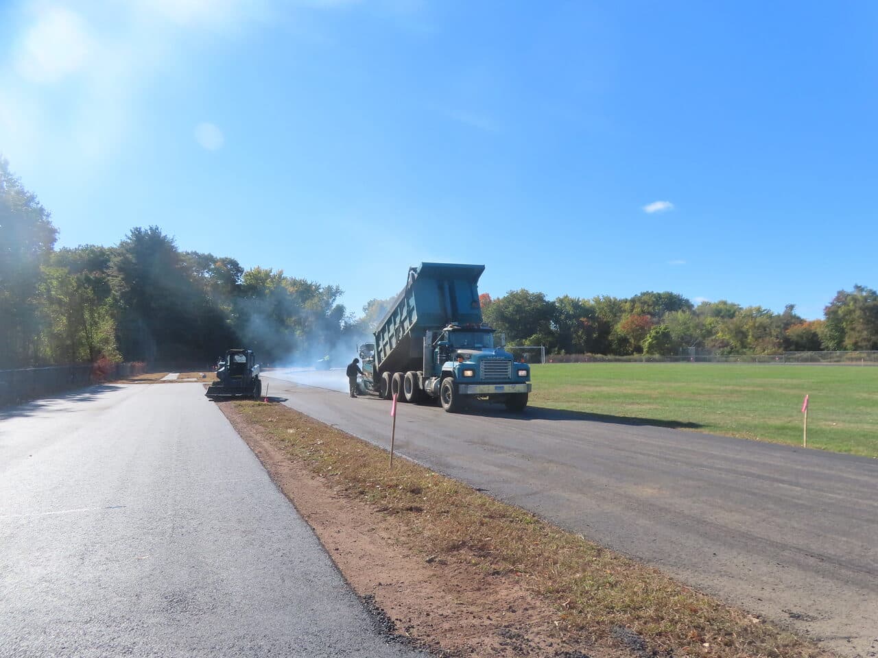 Athletic Surface Base Paving project in East Windsor, CT — dump truck feeding paver on track