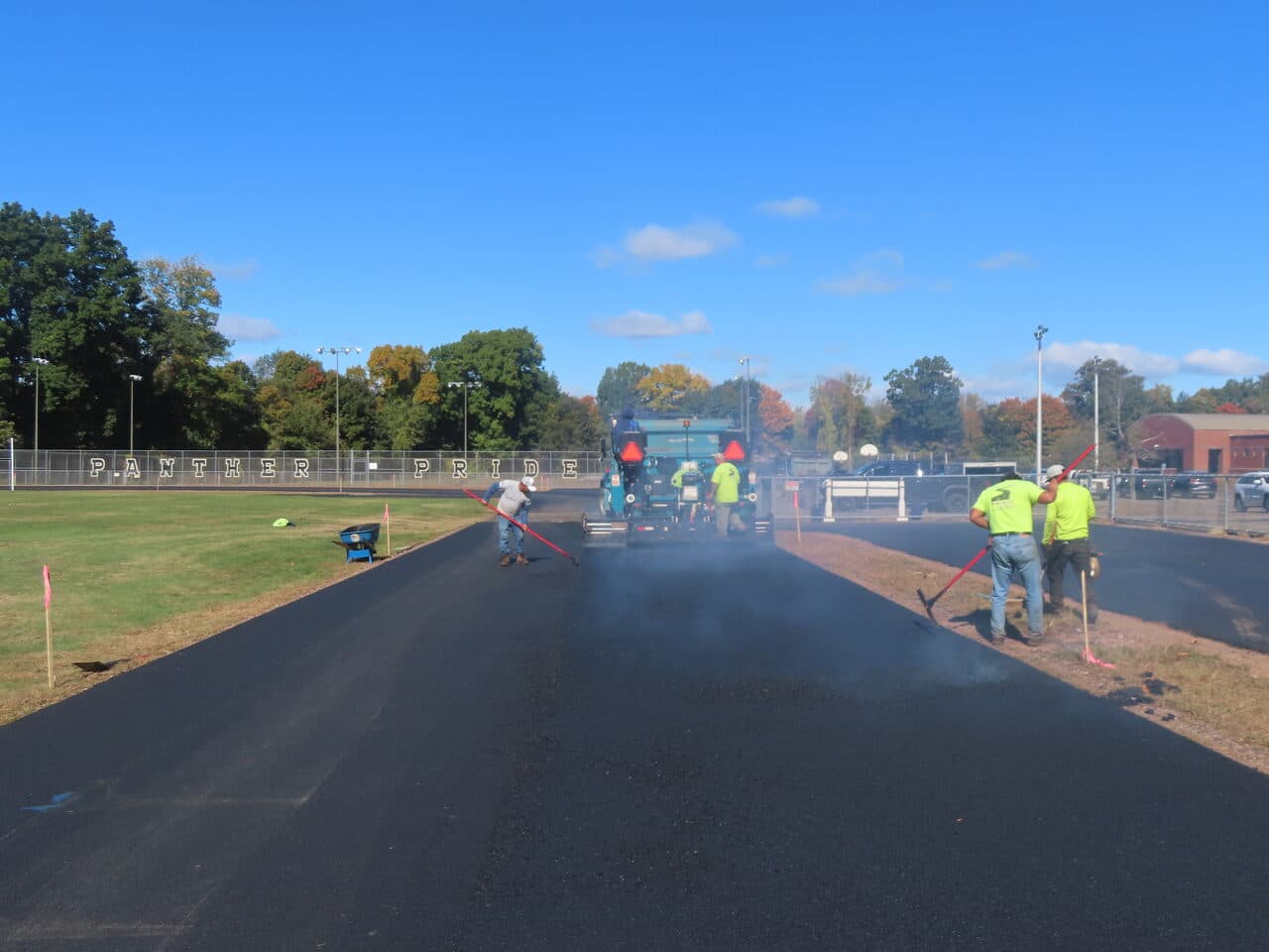 Athletic Surface Base Paving project in East Windsor, CT — crew paving track Panther Pride field