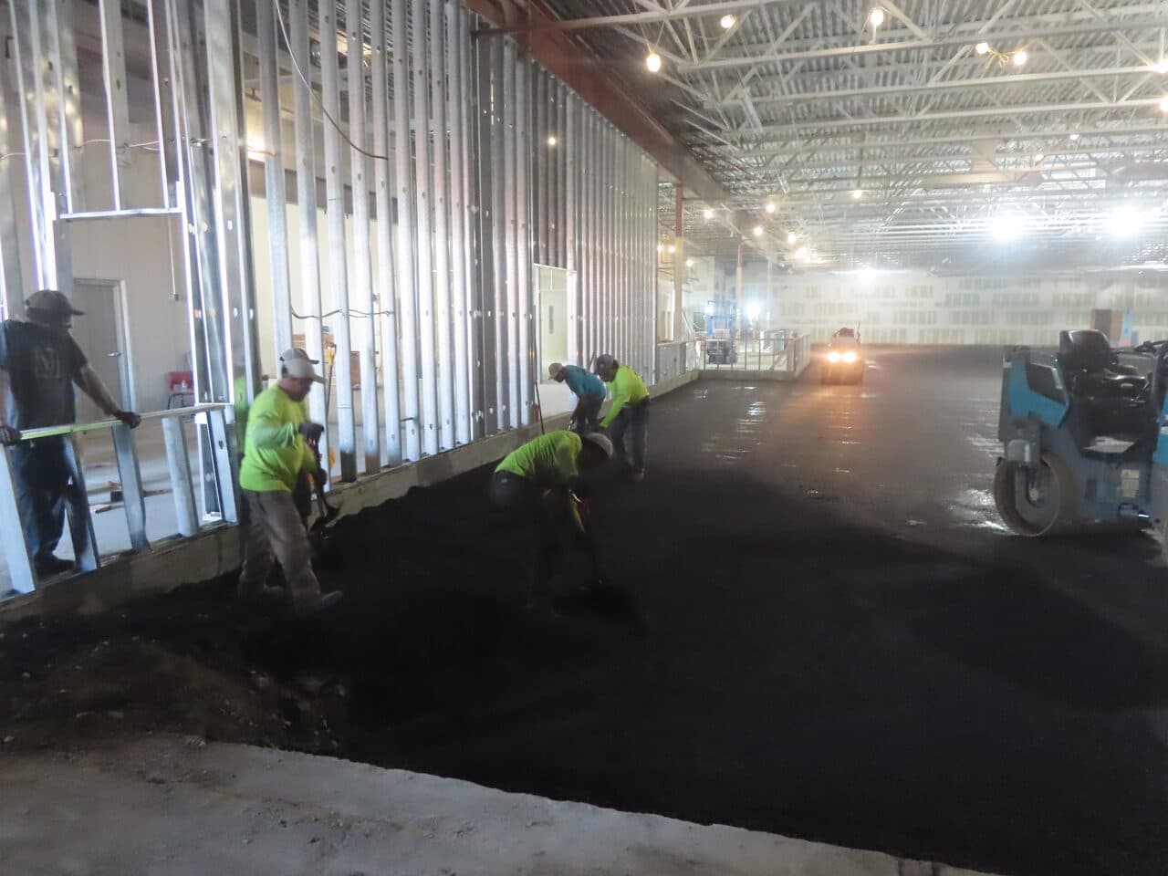 Commercial Parking Lot Paving project in Newport, RI — crew hand raking asphalt along wall