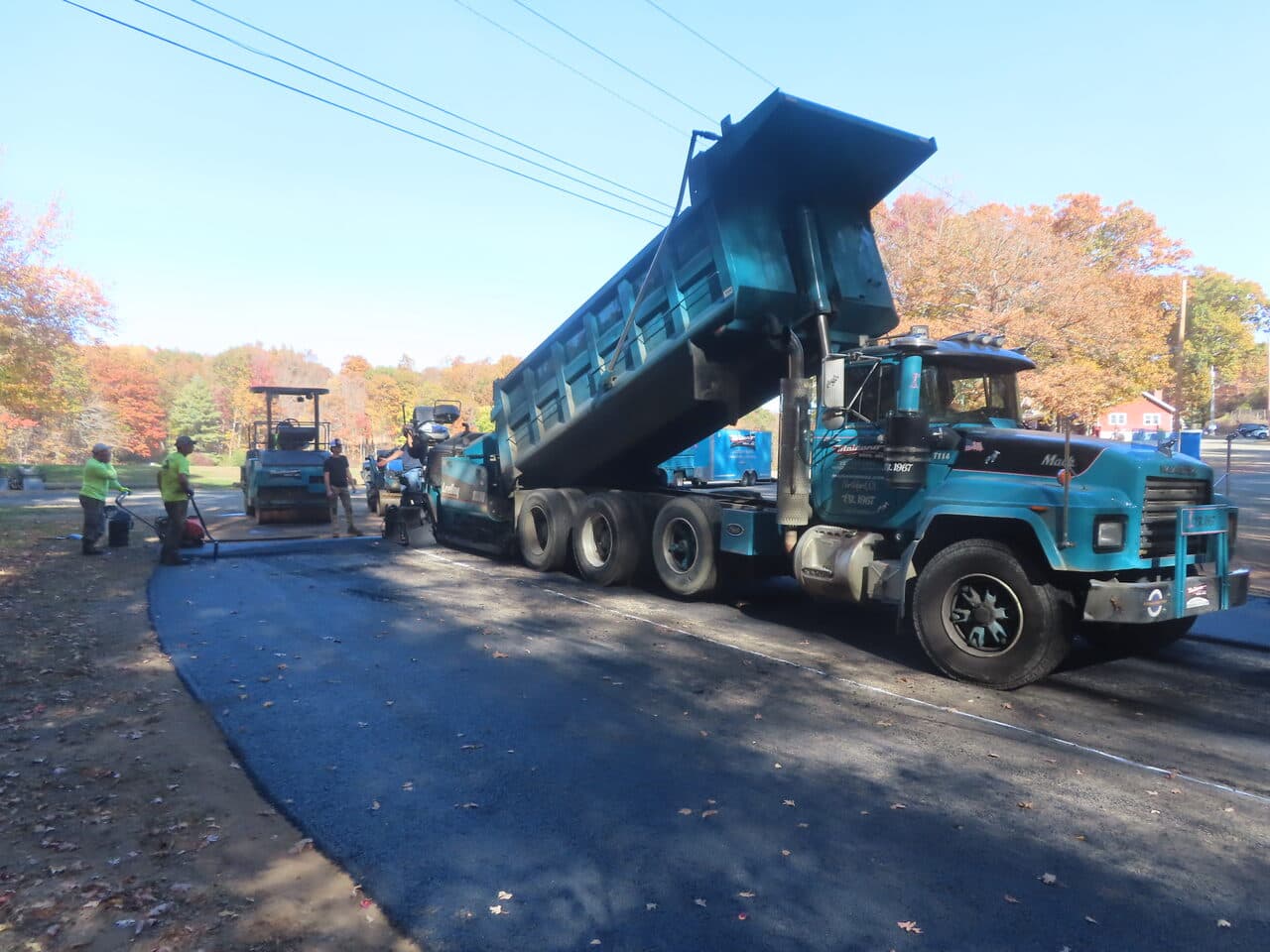 Roadway Paving project in Wallingford, CT — dump truck feeding paver on road