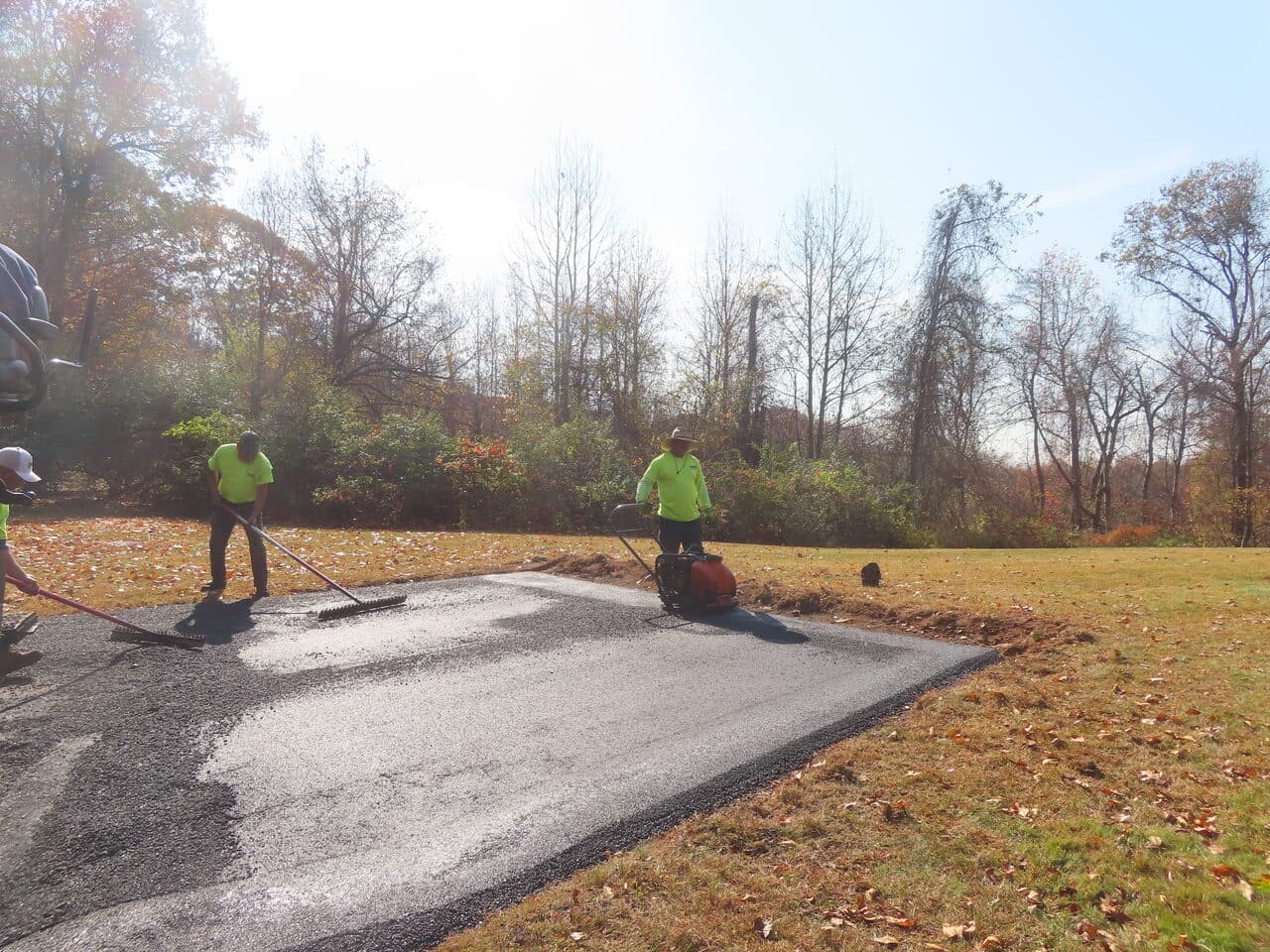 Roadway Paving project in Durham, CT — crew raking and compacting asphalt apron