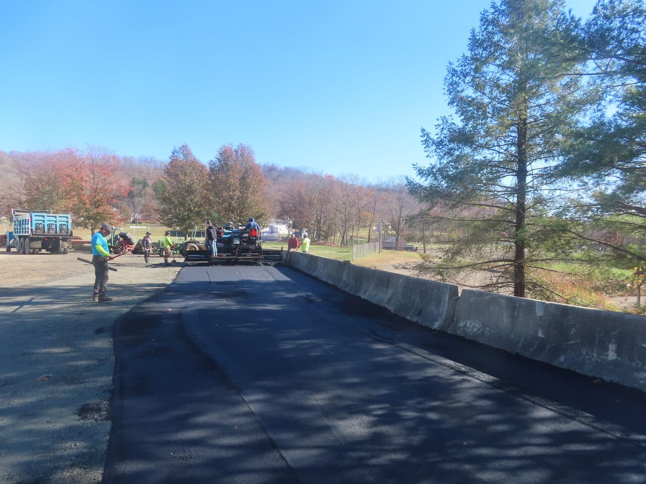 Roadway Paving project in Northford, CT — crew paving lot by barrier wall