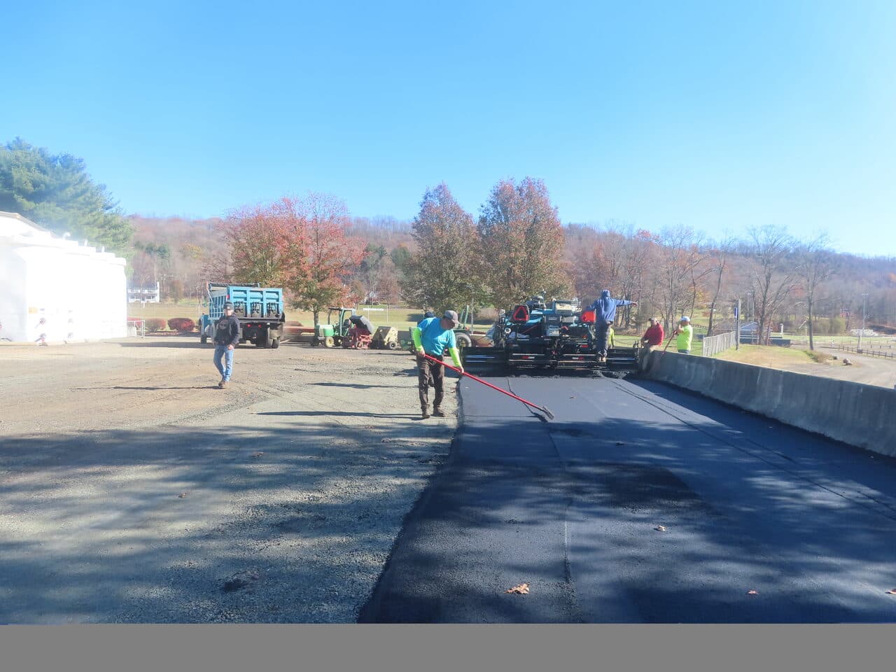 Roadway Paving project in Northford, CT — worker raking fresh asphalt edge