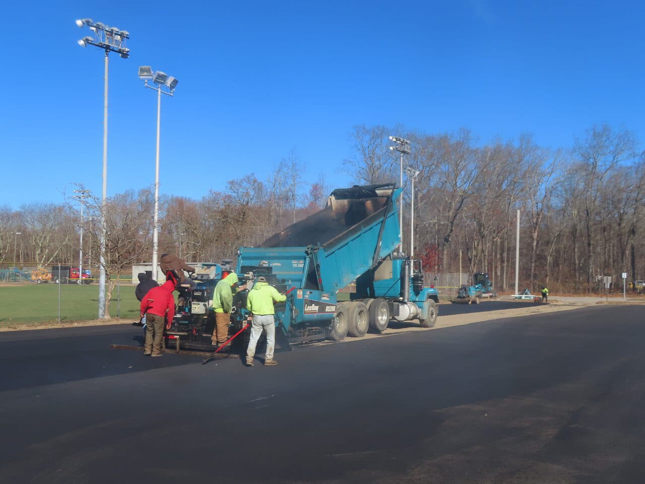 Commercial Parking Lot Paving project in Montville, CT — crew paving lot beside ballfields